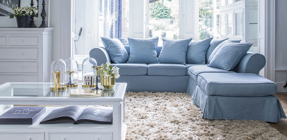 salon avec grand canapé d'angle en lin bleu avec jupe