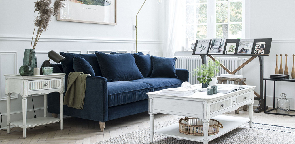 salon style Directoire avec table basse et bout de canapé blanc et canapé en velours bleu paon